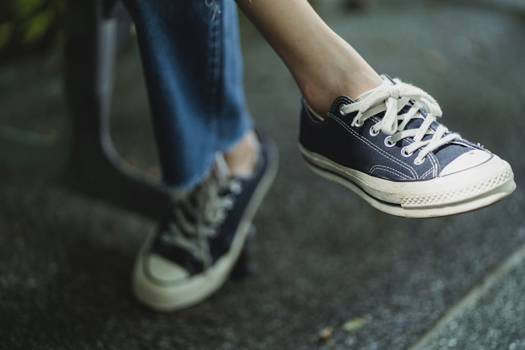 Faceless person in modern footwear on pavement